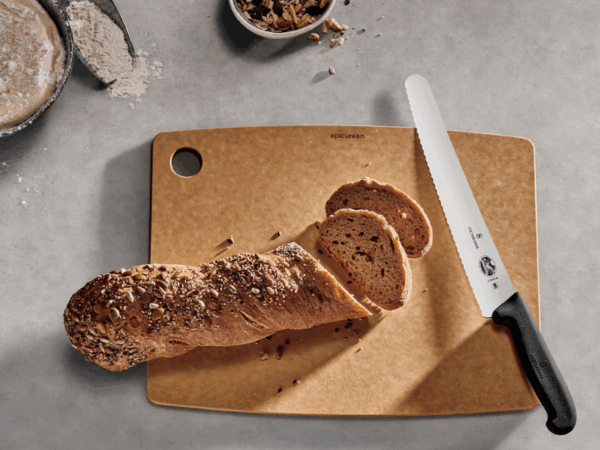 fibrod brotmesser mit schwarzem griff mit geschnitteren brot auf braunem schneidbrett