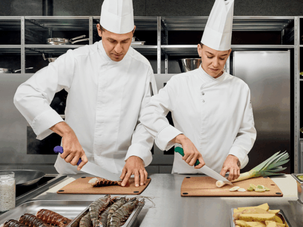 Köche schneiden lauch und krebse mit berufsmesser kochmesser in einer gastro küche